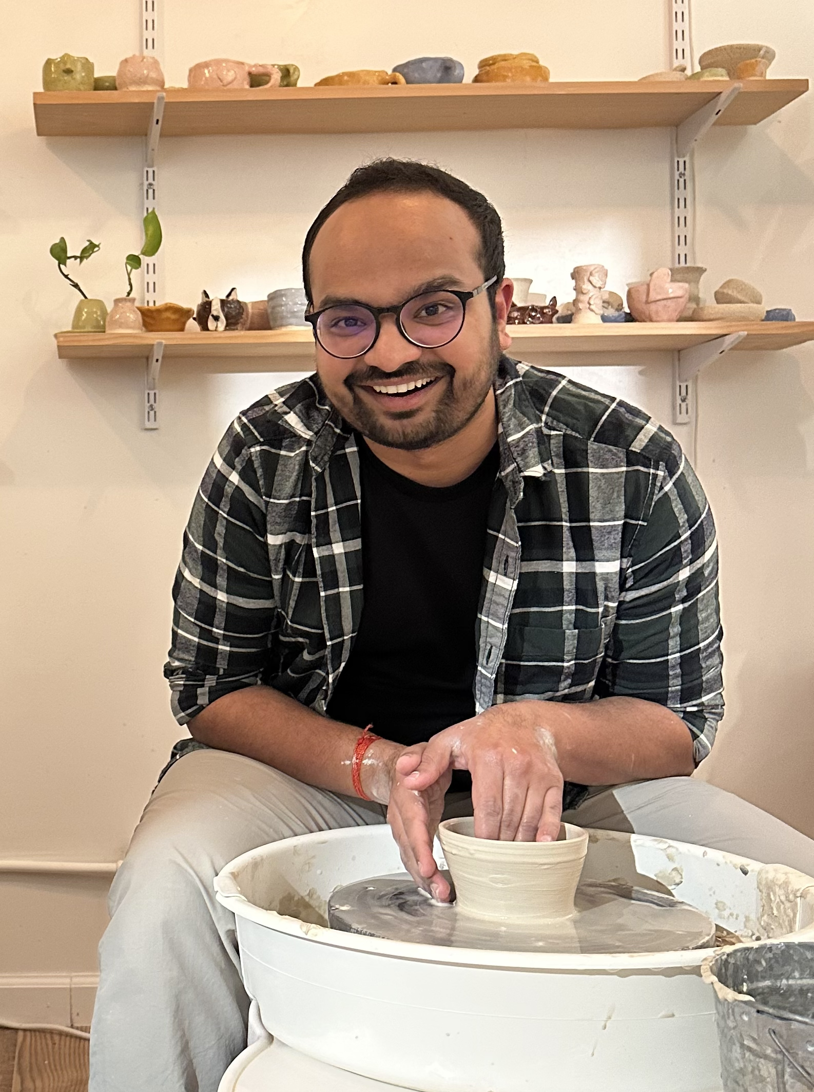 Shivam Lakhotia at a pottery wheel in a studio, shaping clay